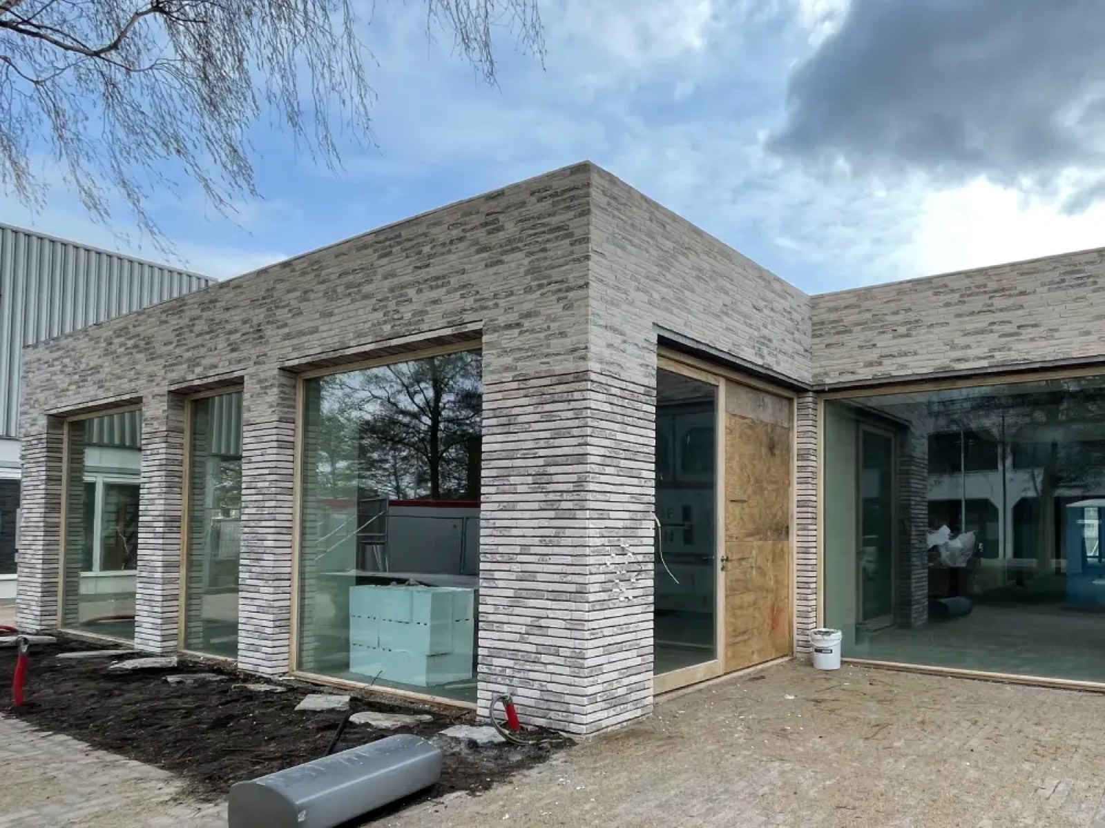 Modern gebouw met lichtgrijze steenstrips-gevelisolatie in aanbouw