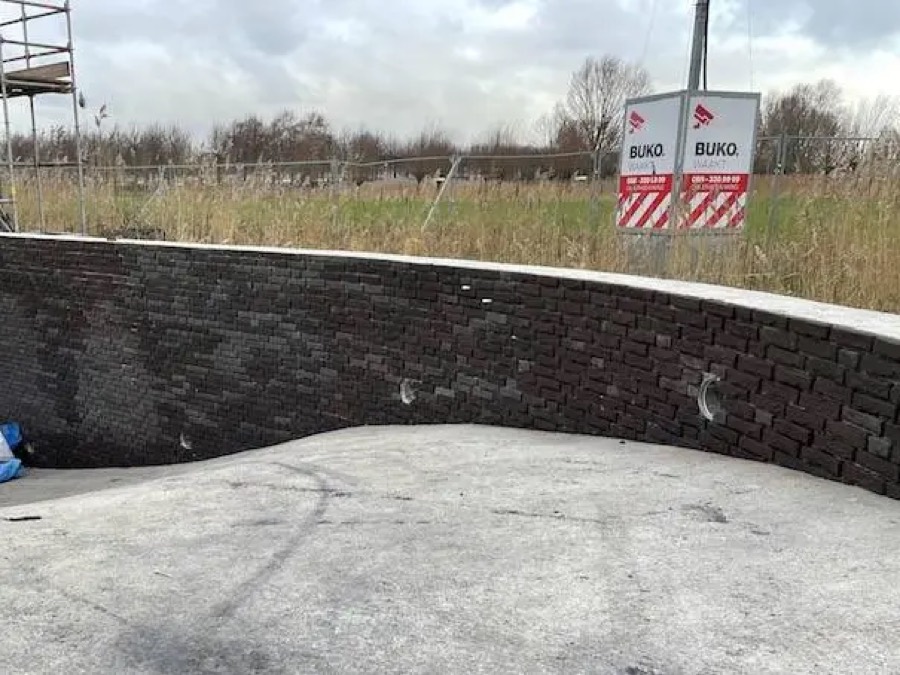 Detail van een gebogen gevel met steenstrips-isolatie, nog in aanbouw
