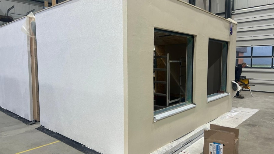 Prefab gevelelement met isolatie en sierpleister in aanbouw, in een werkhal