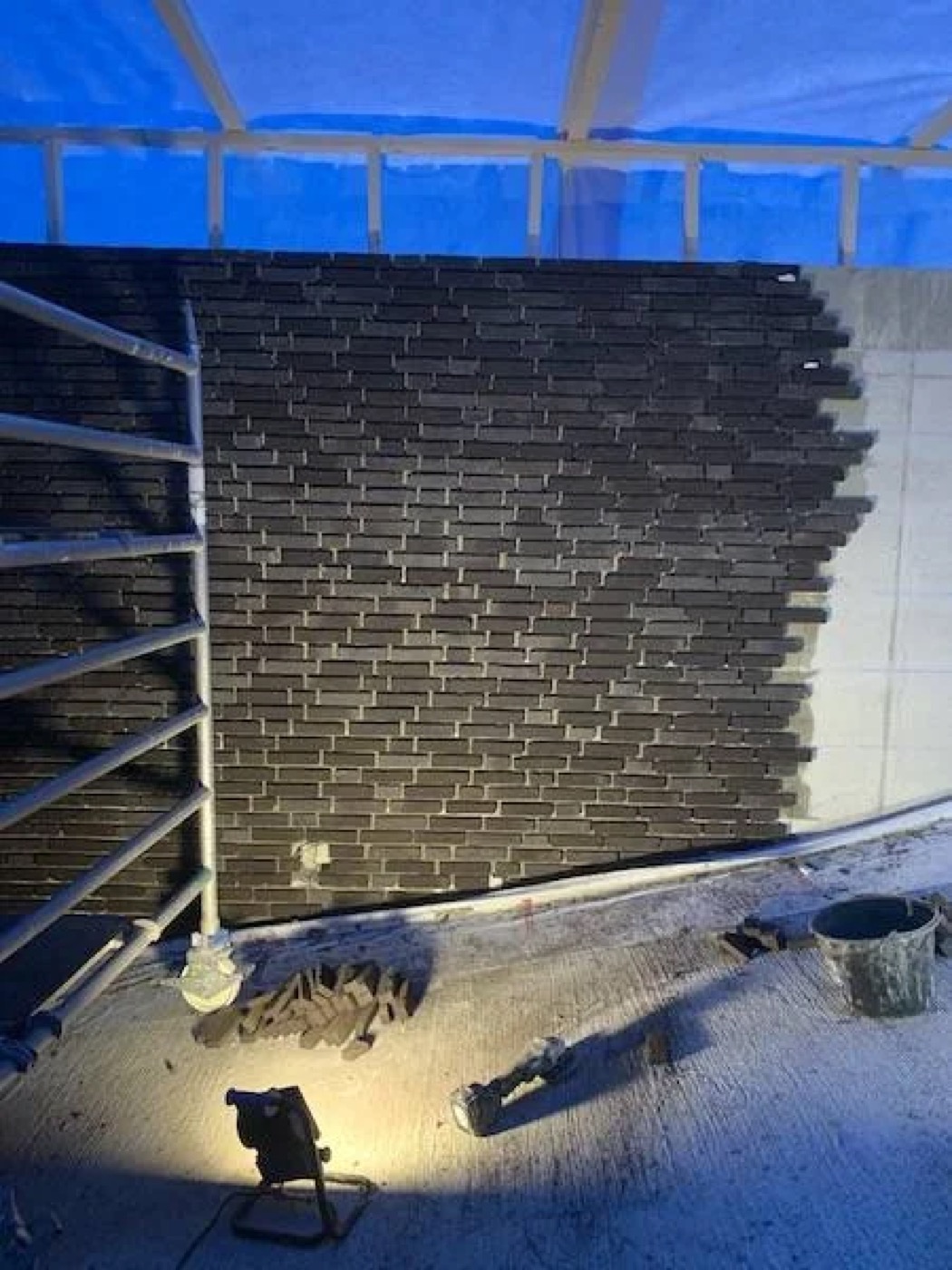 Steenstrips in donkere kleurstelling aangebracht op een betonnen gevelondergrond in Alkmaar