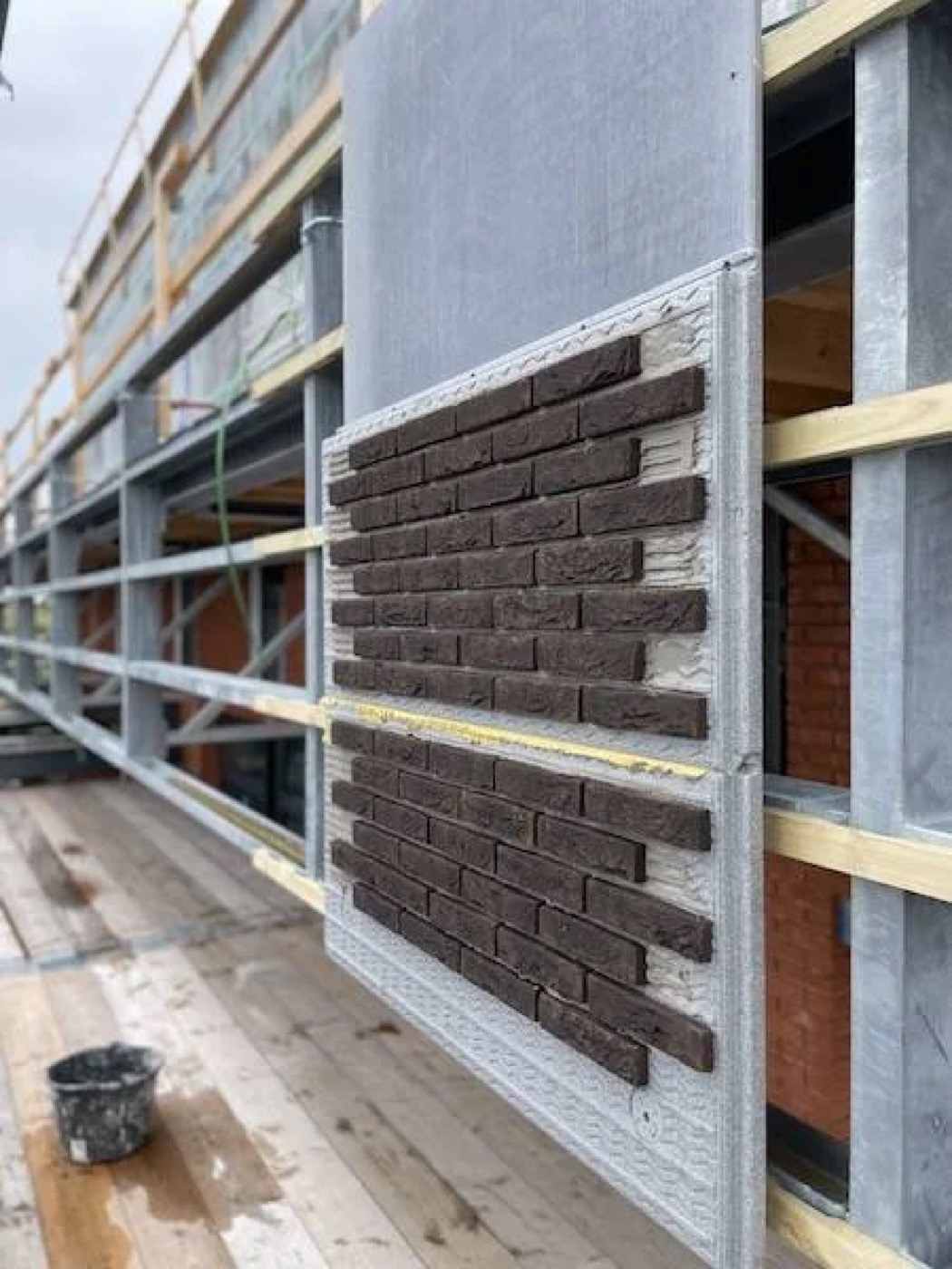 Prefab gevelpaneel met bruine steenstrips gemonteerd op de stalen gevelconstructie van Van der Valk Hotel Almere