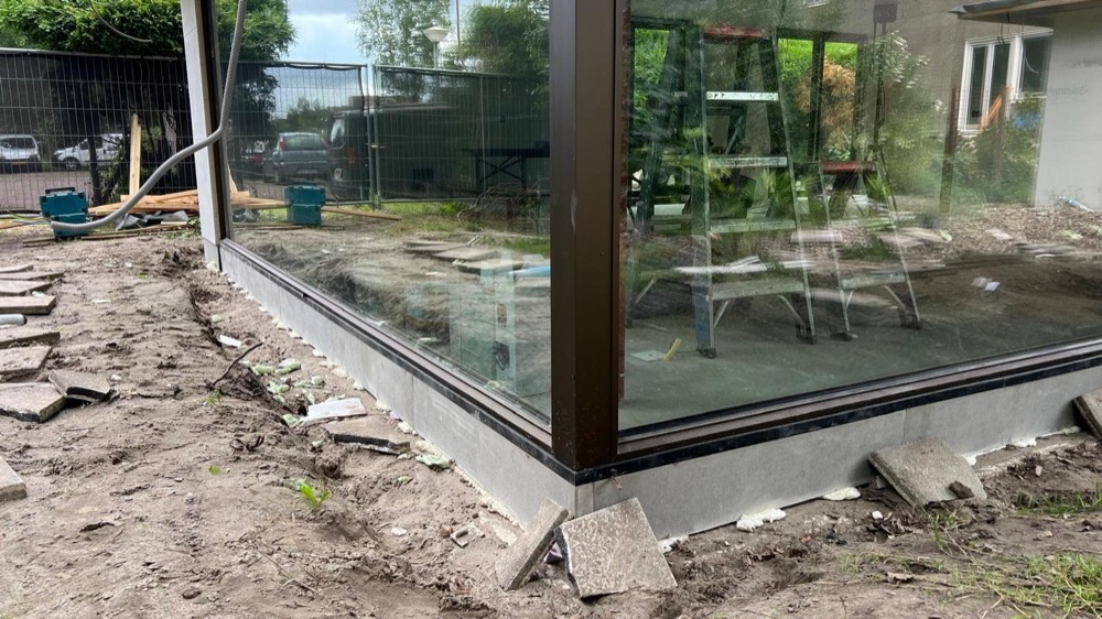 Steenstrips-afwerking rond een raamkozijn bij het woonhuis in Amsterdam-Noord