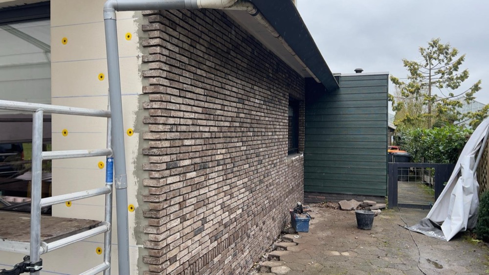 EPS-isolatieplaten met pluggen zichtbaar vóór de steenstrips-afwerking bij het woonhuis in Andijk