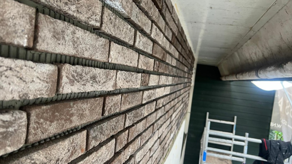 Afgewerkte gevelhoek met steenstrips bij het woonhuis in Andijk