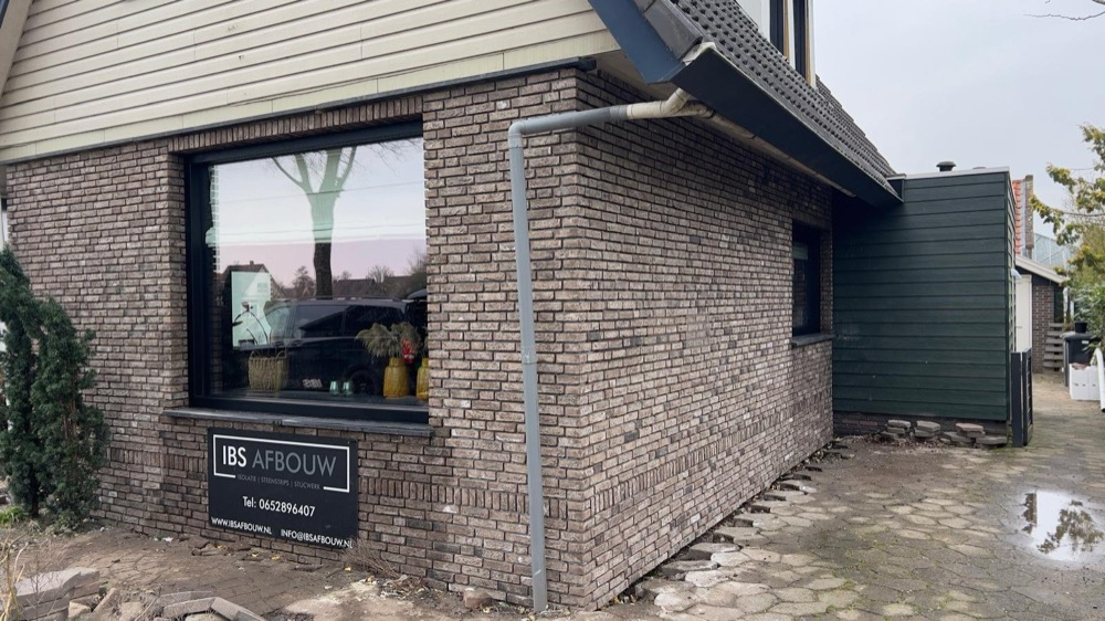 Zijaanzicht van de geïsoleerde en afgewerkte gevel bij het woonhuis in Andijk