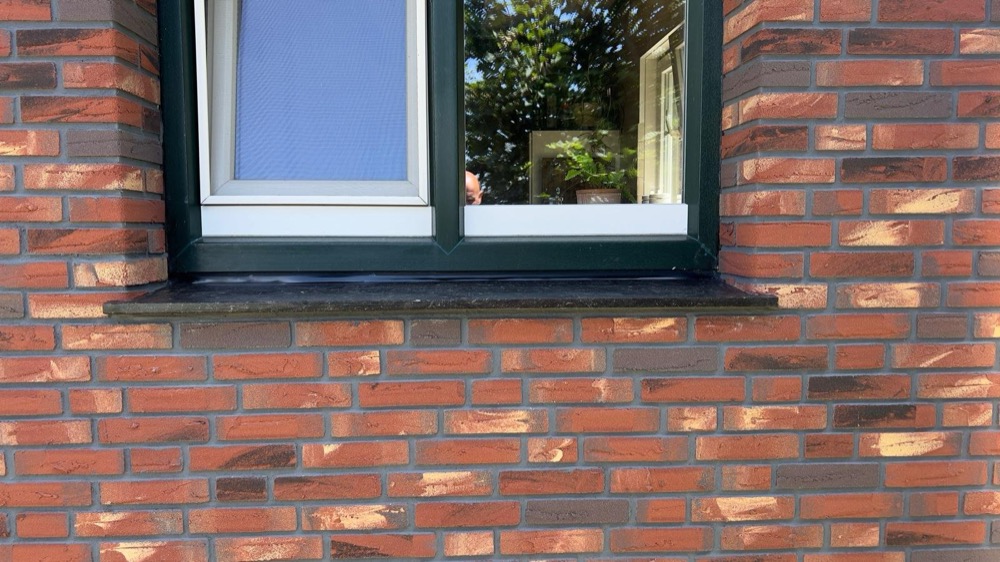 Overzicht van de gevel met minerale steenstrips bij het woonhuis in Callantsoog
