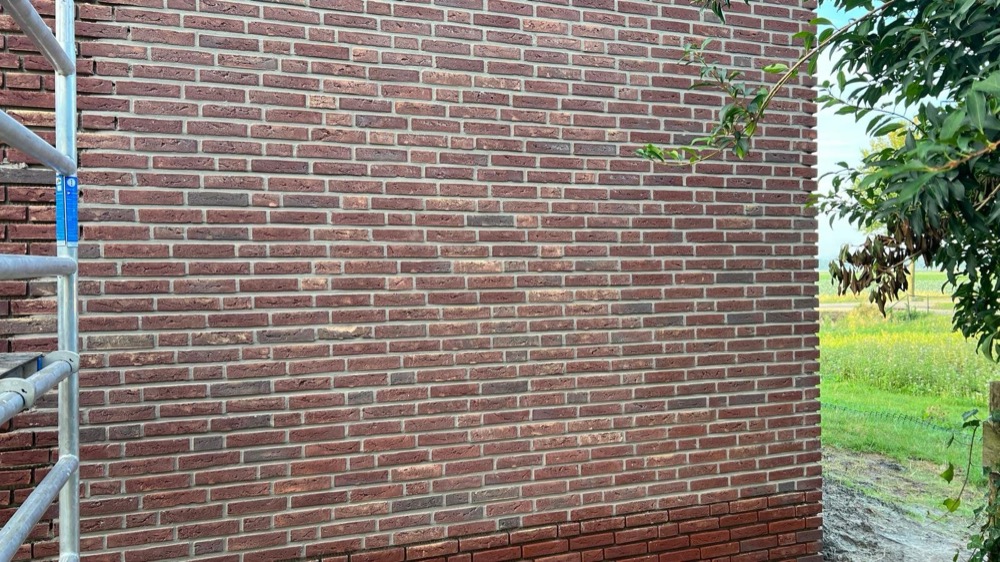 Gevelhoek met minerale steenstrips bij het woonhuis in Langedijk